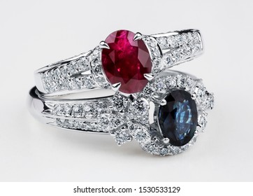 Diamond rings with sapphire and ruby on white background. Rings with diamonds and  large sapphire. Golden wedding rings. White gold. - Shutterstock ID 1530533129