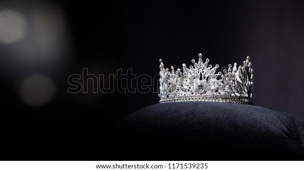 Diamond Silver Crown for Miss Pageant Beauty\
Contest, Crystal Tiara jewelry decorated gems stone and abstract\
dark background on black velvet fabric cloth, Macro photography\
copy space for text\
logo