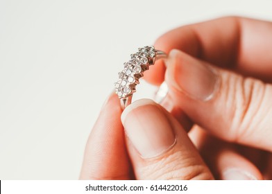 The diamond wedding ring is on the woman's finger. To be a future bride, closeup of daimond selective focus and with a very shallow depth of field, with copy space.