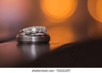 Diamond Wedding Ring And Tungsten Metal Band With Candlelight Glow.