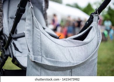 A Diaper Bag Is Hanging On Stroller In The Park