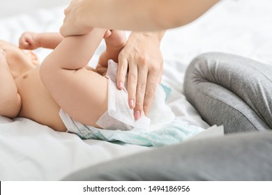 Diaper Change. Mother Cleaning Buttocks Of Newborn Baby With Wet Wipes