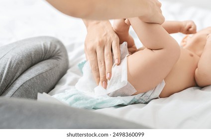 Diaper change. Mother cleaning buttocks of newborn baby with wet wipes - Powered by Shutterstock