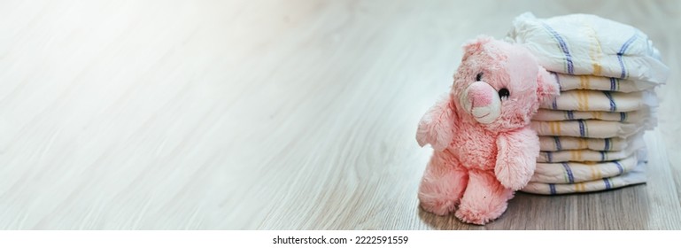 Diapers With A Pink Teddy Bear. Hygiene Of Newborns. Child Care For Dry Body. Stack Of Soft Hygienic Diapers To Protect Against Contamination In Case Of Urinary Incontinence..