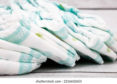 Diapers stacked vertically from left to right. Mention the amount of diapers needed to care for babies throughout their life cycle and the dedicated work of parents.