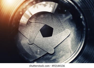 The Diaphragm Of Old Camera Lens Aperture With Warm Light Bokeh. Selective Focus With Shallow Depth Of Field. Vintage Color Tone Filtered. Abstract Texture Background.