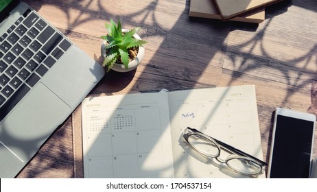 Diary And 2022 Calendar Desk For Planner To Management Daily Agenda, Appointment, And Timetable For A Job. Laptop Smartphone Glasses Cactus And Diary Placed On Table. Working Online At Home Concept