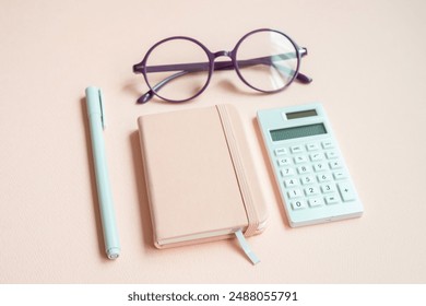 Diary notebook, pen, eyeglasses, calculator on pink desk background - Powered by Shutterstock