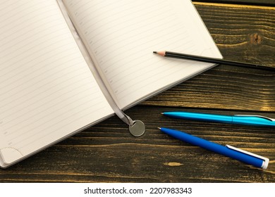 Diary for notes on a wooden table, pen and pencil