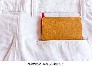 Diary And Pen In White Pants Pocket.