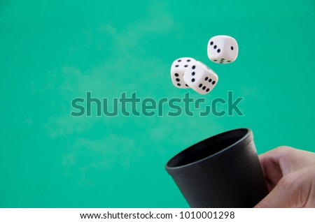 Dice in the air on green background