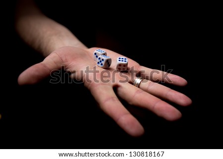 dice on a palm, isolated black background