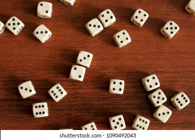Dice are scattered on a wooden table. Cubes lie in random order. Slight blur. - Shutterstock ID 1090492043