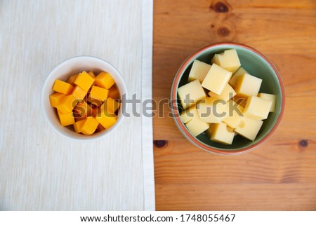 Diced cheeses laying in ceramic bowls. Gourmet, product, ingredient. Studio shot. Top view. Dairy meal and cooking on isolation concept for flyers and banners