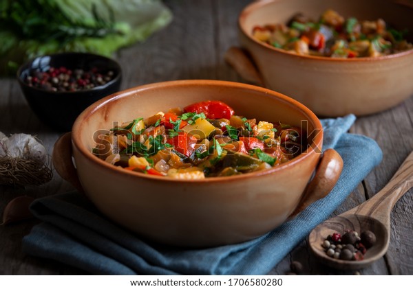 Diced cooked\
vegetables on dark wood. Traditional ratatouille with zucchini,\
bell pepper and eggplant