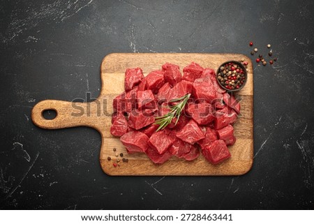 Diced cut raw beef cubes wooden cutting board red meat cooking protein top view
