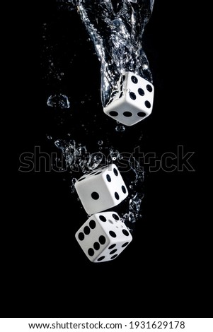 Dices sinking in water with bubbles on black background in water with bubbles on black background