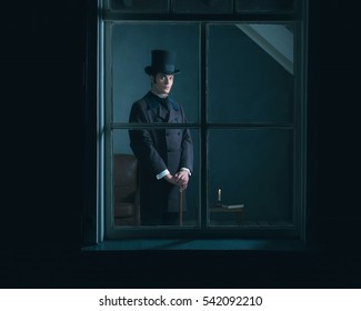 Dickens style man standing with cane behind window.