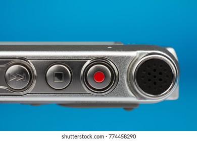 dictaphone closeup of a red record button selective focus blue blurred background journalism concept