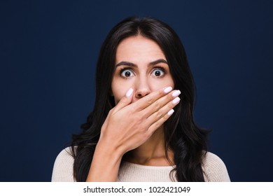 I Did Not Sad That! Portrait Of Beautiful Young Woman Covering Her Mouth And Looking At
Camera While Standing At Black Background
