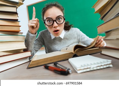 Did you know that?! Curious student reads a books. Photo of astonished young girl wearing glasses pointing finger up. Education concept - Powered by Shutterstock - Get 15% off with code: PIKWIZARD15