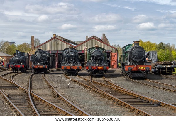DIDCOT, OXFORDSHIRE, UK -\
MAY 1, 2016: A view across the rail yard, and a lineup of Great\
Western Railway locomotives, at the Didcot Rail Centre during their\
Steam Gala.
