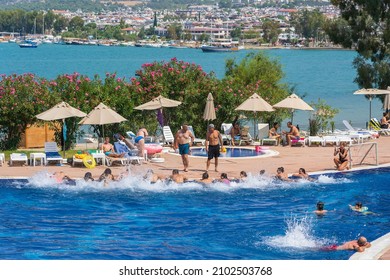 Didim, Turkey - september 03, 2019 : People do aerobics, swim and sunbathe in the swimming pool next to the sea in the resort hotel in Didim, Turkey. The concept of vacation and entertainment