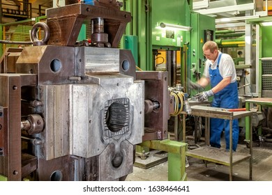 Die Casting Machine And Skilled Worker Who Is Working In The Bac