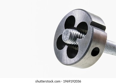 Die for cutting threads in a screw during operation. Mechanical accessories in a locksmith's workshop. Isolated background.