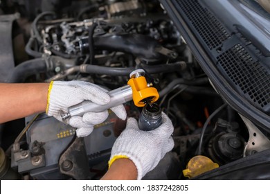 Diesel engine during service, or maintenance at the garage. Technical wear a glove and open the suction tube to analyze oil. Design of the old engine. Service, repair, and analysis concept