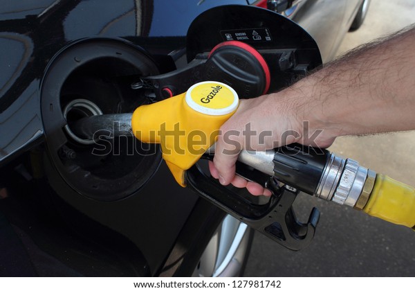 Diesel fuel at\
the french filling station. Close up of the man\'s hand and fuel\
filling pistol.  Gazole in\
France.