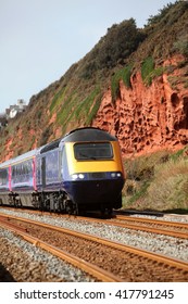 A Diesel Locomotive On The South Devon Railway Near Dawlish With Red Cliffs Behind