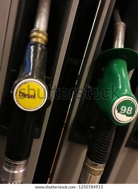 Diesel and petrol\
pumps on a gas station. 