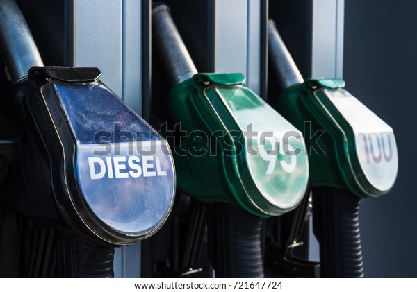 Diesel text, 95 and 100 high octane and\
quality gasoline numbers on fuel pistols of gas station refueling\
stand - transportation, oil business or environmental pollution\
theme closeup background