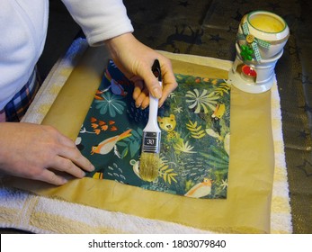 Diest, Belgium - January 2020: Apply beeswax on cotton fabric with brush