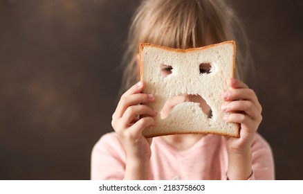 diet celiac. gluten intolerance. sad bread in the hands of a child. Gluten free concept  - Shutterstock ID 2183758603