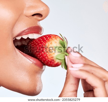 Diet, closeup and woman eating strawberry in a studio for healthy wellness snack for nutrition. Health, beauty and zoom of female model mouth with fruit for natural skin detox by a white background.