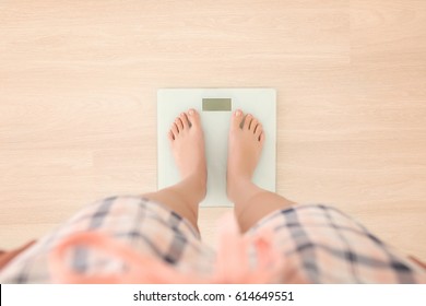 Diet concept. Female bare feet standing on scales