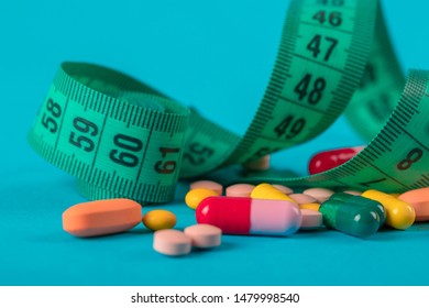 Diet concept; Slim by pills, dangerous for health. Centimeter tape and pills on a colored background with space for text. concept of losing weight, diet, fat burning, healthy eating. minimalism. - Powered by Shutterstock