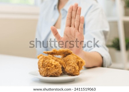 Diet, Dieting concept young woman hand push out, reject fried chicken on plate, deny to eat fast, junk food. Girl avoid, abandon to eat carbohydrates for good healthy, getting fat, weight loss people.