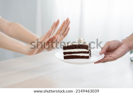 Diet, Dieting unhealthy asian young woman hand in push out, rejecting eat chocolate cake or sweet taste, fighting to keep it from getting fat when person bring to me. Healthy, nutrition of weight loss