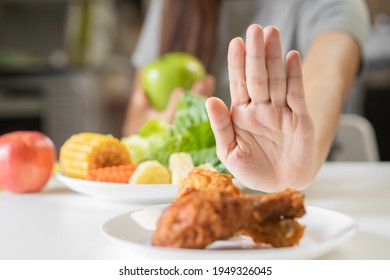 Diet, Dieting young asian woman or girl  push out, deny fried chicken, junk food and choose green apple, vegetables salad, eat food for good healthy, health when hungry. Female weight loss person. - Shutterstock ID 1949326045