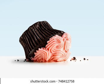 Diet fail concept with smashed cupcake on blue background