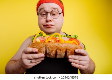 Diet failure of fat man eating fastfood . Happy smile overweight male looking burger