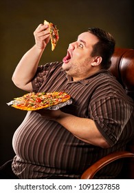 Diet failure of fat man eating fast food slice pizza on plate. Close up of breakfast for hungry overweight person who spoiled healthy food. He can not refuse harmful food.