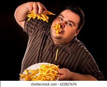 Diet failure of fat man eating fast food . Overweight person who spoiled healthy food by eating french fries. Junk meal leads to obesity.