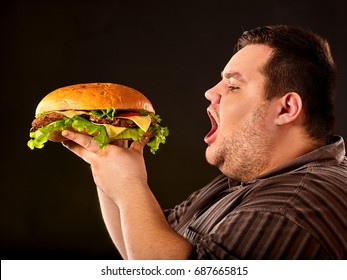 Diet Failure Of Fat Man Eating Fast Food Hamberger. Breakfast For Overweight Person Who Spoiled Healthy Food By Eating Huge Hamburger. Junk Meal Leads To Obesity. Cooking Hamburgers At Home.