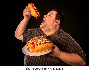 Diet failure of fat man eating fast food hot dog on plate. Breakfast for overweight person who greedily eats lot. Use of semi-finished products for food. Enraged by large amount of food fat.