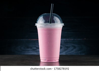 Diet Food and healthy nutrition. Pink Fruit smoothie, cherry milkshake in plastic glass on a dark background. cherry milkshake in takeaway cup - Powered by Shutterstock