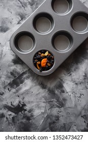 Diet And Healthy Eating Minimalist Style Concept. Dried Fruits In Empty Muffin Pan On Dark Background Top View Copyspace